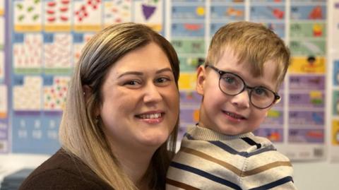 Mum Jess is pictured on the left, and Finley is pictured on the right in a stripey top and glasses. 