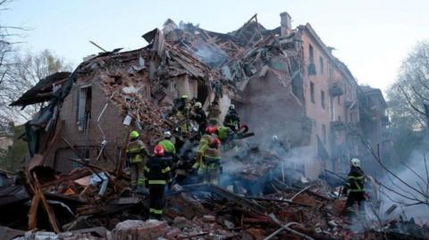 Rescue workers searching the ruins of a collapsed building in Ukraine 