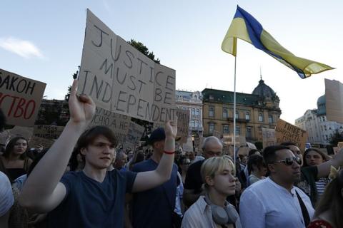 A young man holds a placard reading "Justice must be independent" during a protest in Lviv