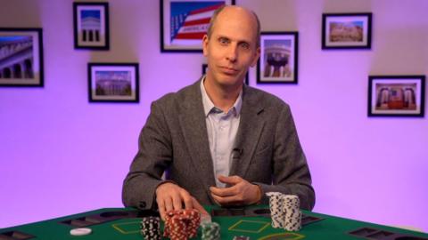 Anthony is playing poker while talking to the camera.