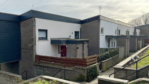 Row of buildings in Aberdeen, with fencing, paths and steps visible