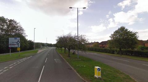 A Google street view of road with two-lane carriageways on each side. 