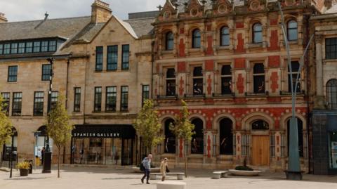 People walking past the Spanish Gallery in Bishop Auckland town centre.