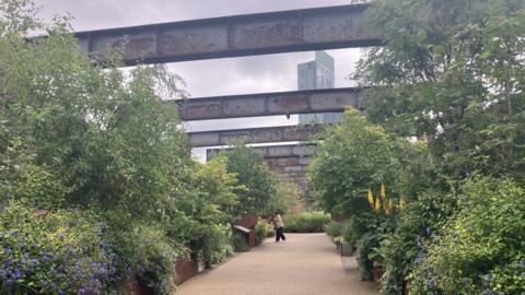 Flowers and plants line a section of Castlefield Viaduct in Manchester.