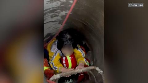 Girl being rescued by firefighters after being stuck in a drain for seven hours.