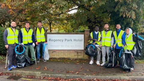 Residents of Regency Park hotel stood next to sign