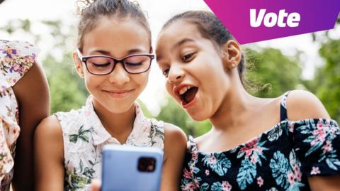 two girls looking at a mobile phone