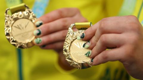 Gold medallists Australia's Jessica Gallagher and pilot Caitlin Ward celebrate on the podium during their the medal presentation ceremony for the women's para-sport sprint B tandem race on day one of the Commonwealth Games, at the Lee Valley VeloPark in east London, on July 29, 2022.