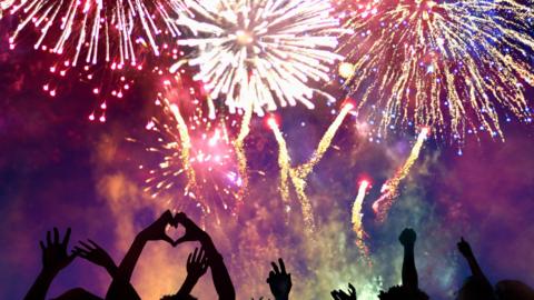 A crowd of people enjoying a fireworks display.