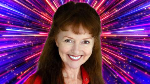 Melanie Walters smiling and wearing a red top, with the pink and purple Strictly Come Dancing background