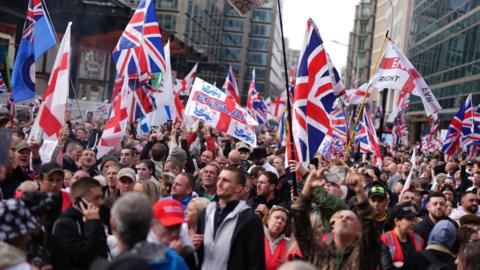 Supporters of a Pro-UK rally endorsed by Tommy Robinson march from Victoria Station to Parliament Square in central London