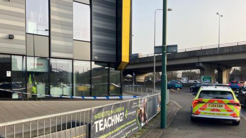 Police vehicle near a cordon at a school
