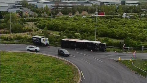 Camera shot of the overturned lorry, laying on its side, on the entry slip road