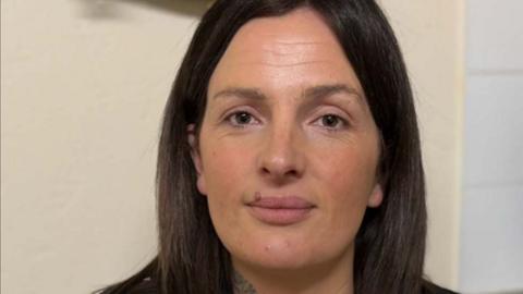 A women with brown hair looking directly at the camera