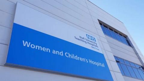 A sign on the outside of the hospital wall in white lettering on a blue background saying Women and Children's Hospital.