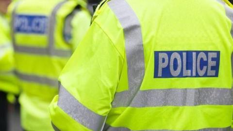 Generic photo of the back of police officers, with high-vis jackets.