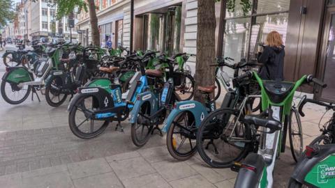 A range of Forest and Lime bikes parked on a pavement in Westminster
