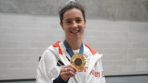 Imogen Grant shows off her gold medal during a visit to Stephen Perse school in Cambridge.