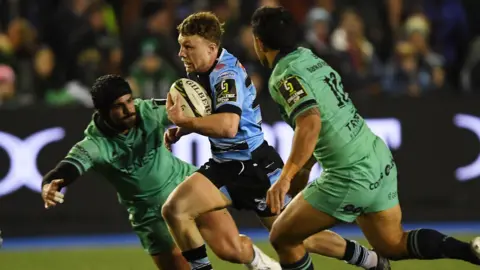 Tom Bowen of Cardiff is challenged by Josh Ioane of Connacht