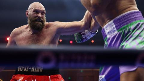 Tyson Fury aims a jab at an opponent in the ring