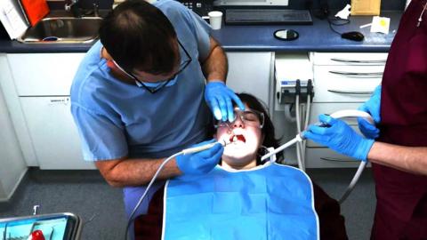 A dentist giving treatment to a patient.