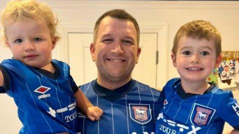 David Moore and his sons, Henry and George, in their Ipswich Town football kits