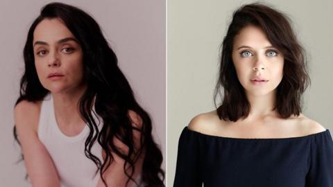 Hayley Squires has long black hair and is wearing a white vest. Bel Powley has shoulder length black hair and is wearing a black top