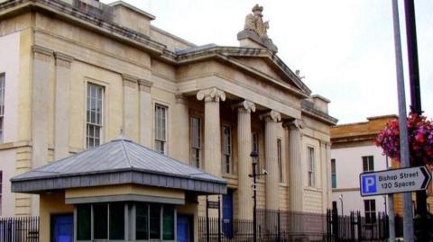 Bishop Street courthouse with a parking sign outside 