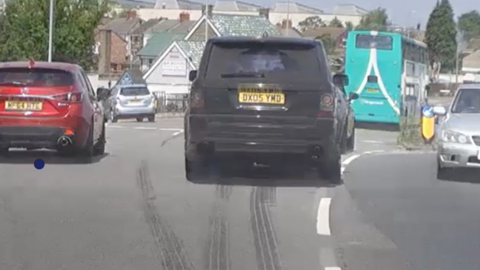 A black range rover driving in traffic