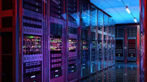 A purple, pink and blue glow surrounds rows of data centre server racks. There are several wires, folders and slots behind glass doors. The floor is clean and reflects the racks.