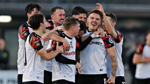 Corey Shephard is mobbed by Haverfordwest team-mates after his equaliser against Caernarfon Town