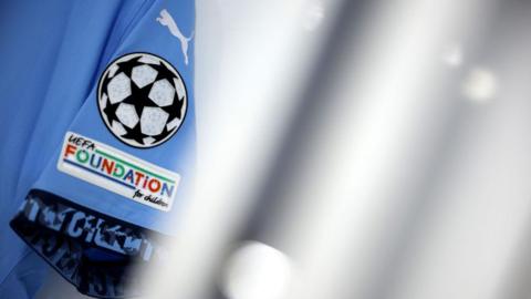 A general view of Champions League/Uefa branding on the sleeve of a Manchester City shirt