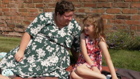 Charlotte Brown sat in the garden with her daughter Poppy. 