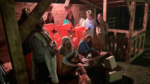 Characters in a stable include three wise men riding inflatable camels, the Angel Gabriel, Mary and Joseph and baby Jesus in a crib.