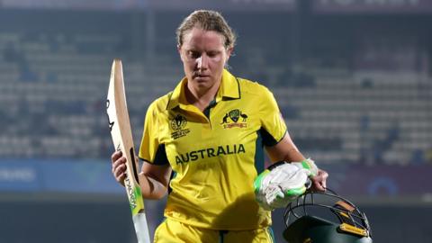 Australia captain Alyssa Healy raises her bat as she walks off after being dismissed for 142