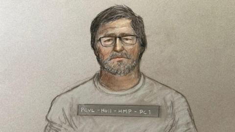 Court artist picture of Vladimir Motin he has short dark hair and beard and is wearing glasses and a grey top