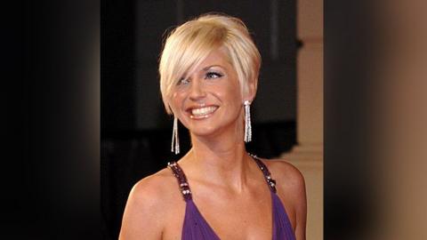 Sarah Harding, with short blonde hair and wearing silver dangly earrings and a purple dress, arrives at an awards ceremony in 2007.