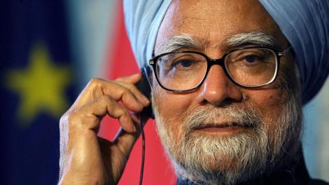 Manmohan Singh in a press conference in Germany in 2006, in a blue turban and black reading glass, seen adjusting his earphone