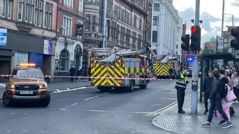 Upper Parliament Street in Nottingham, with red fire cordon tape across the road and two fire appliances parked in the carriageway