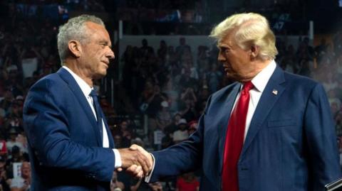 Former Republican presidential candidate Robert F. Kennedy Jr. and Republican presidential nominee, former U.S. President Donald Trump shake hands during a campaign rally at Desert Diamond Arena on August 23, 2024 in Glendale, Arizona