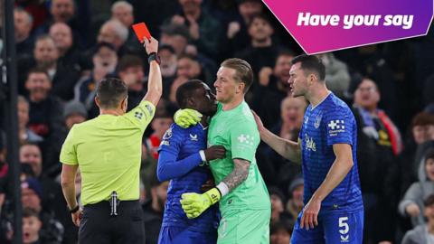 Idrissa Gueye of Everton is shown a red card by Referee Tony Harrington after clashing with teammate Michael Keane as he is restrained by Jordan Pickford during the Premier League match between Manchester United and Everton.