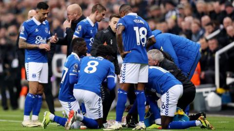 Everton players stand and kneel in a circle to break their fast during a Premier League match