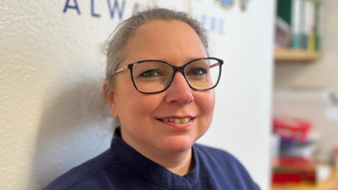A close-up portrait picture of Dr Rachael Wallace. She is wearing glasses.