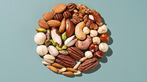 Assorted nuts in a circle on green background