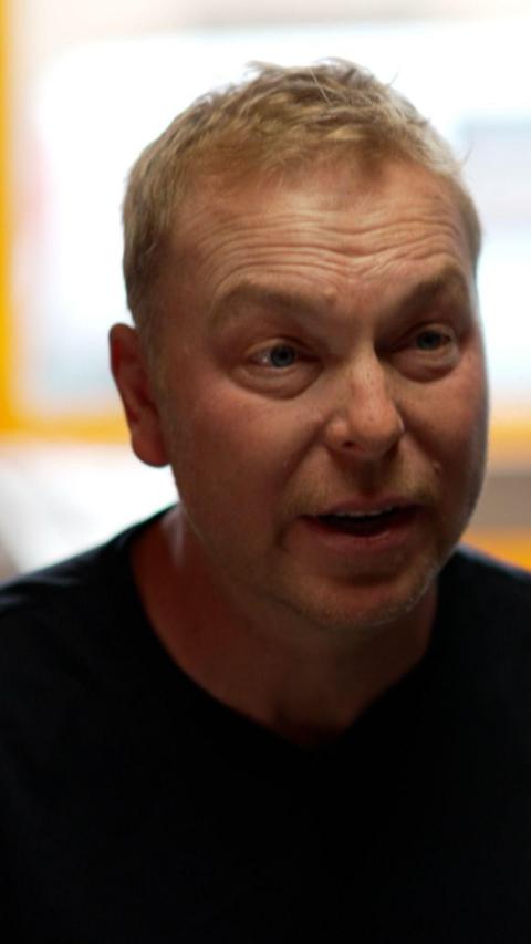 Man with blonde hair slightly raising his eyebrows