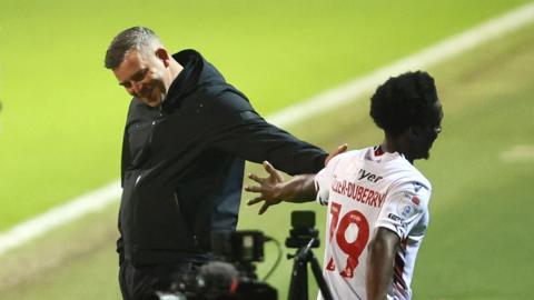 Amario Cozier-Duberry celebrates scoring Bolton Wanderers' third goal against Stevenage with manager Steven Schumacher