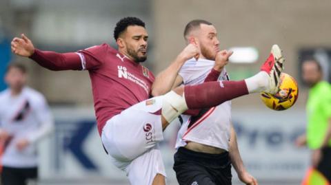 Northampton's Jordan Willis and Lincoln's Ben House challenge for the ball