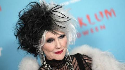 Musk with hair dyed black and white, and a white shawl