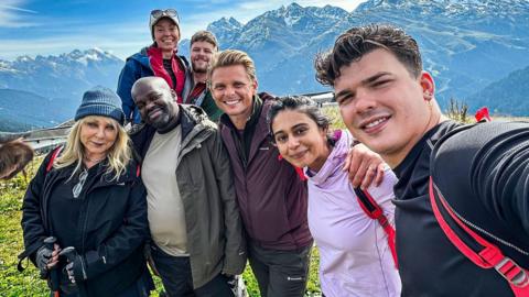 Seven people pose for a selfie in the Swiss Alps