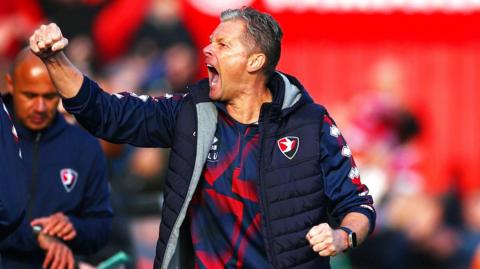 Cheltenham Town manager Steve Cotterill punches the air with his fist in celebration after beating Walsall